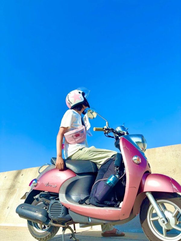 ピンクのスクーターに乗る人物