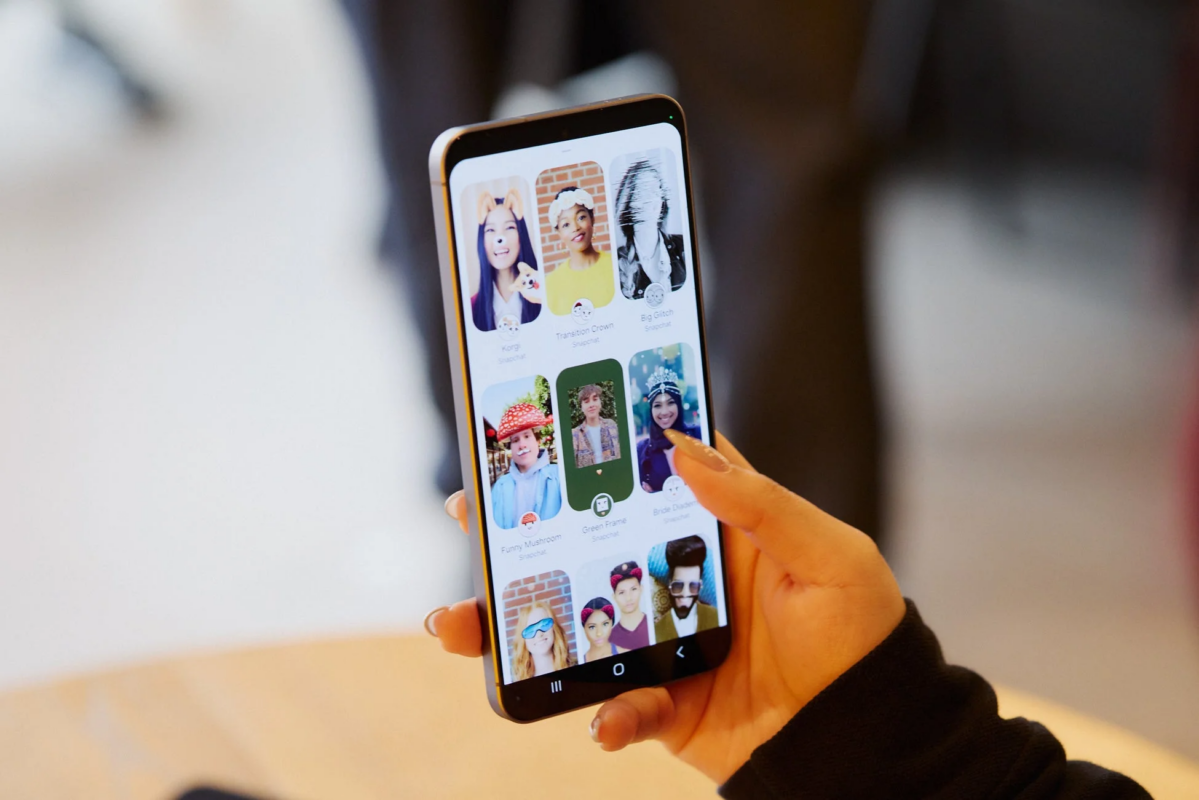 女性がスマートフォンを持ち、Snapchatアプリの様々なフィルターやレンズを閲覧している様子