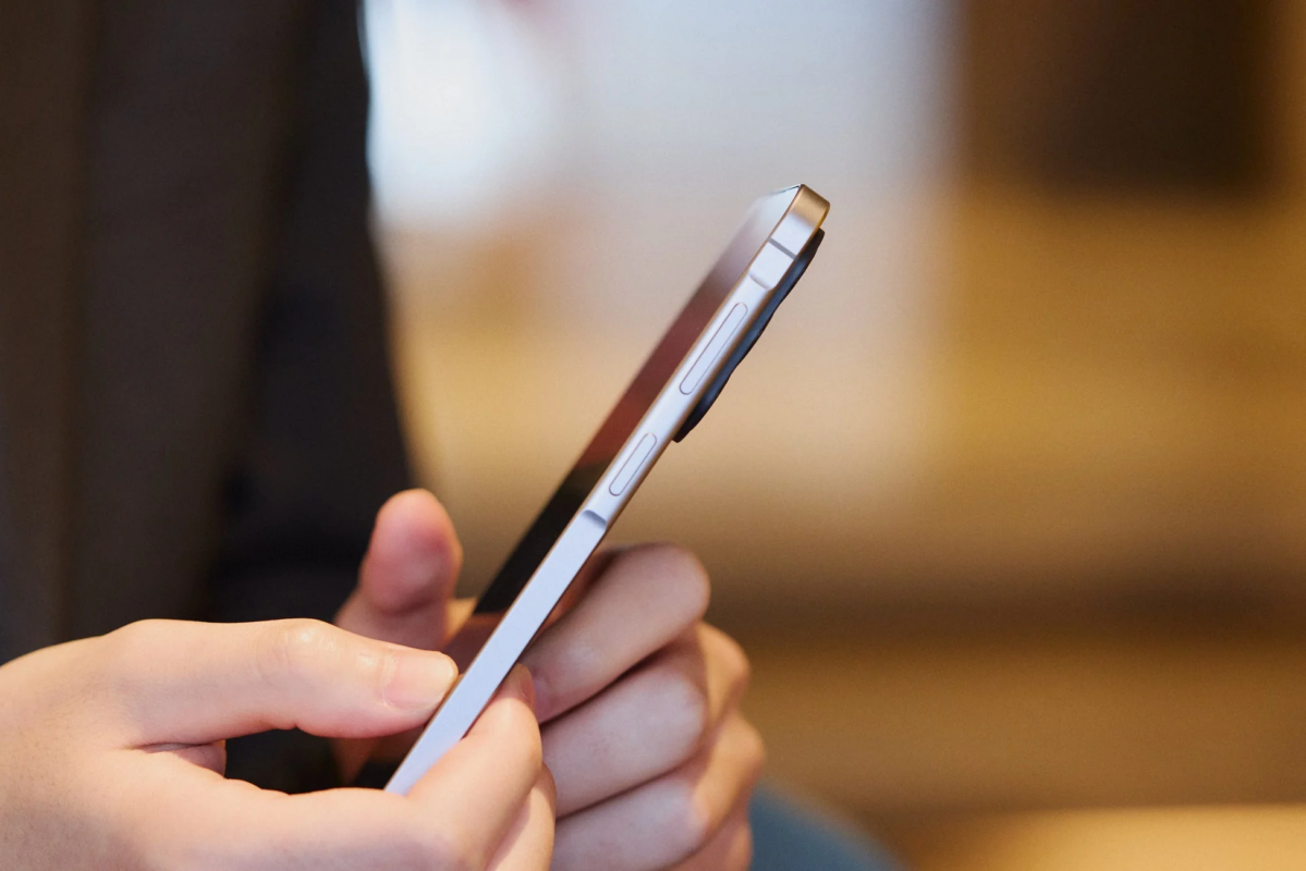 スマートフォンを操作している人物の手元を側面から捉えた画像